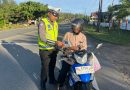 Personel Unit Kamsel Satlantas Polres Aceh Jaya Bagikan Brosur Keselamatan Berlalu Lintas kepada Pengguna Jalan