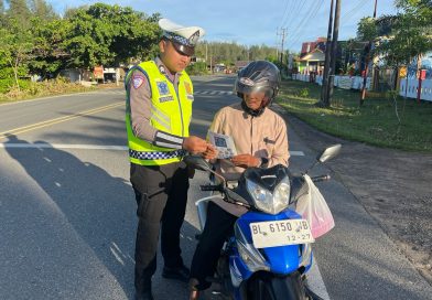 Personel Unit Kamsel Satlantas Polres Aceh Jaya Bagikan Brosur Keselamatan Berlalu Lintas kepada Pengguna Jalan
