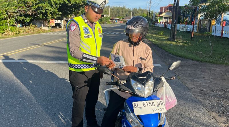 Personel Unit Kamsel Satlantas Polres Aceh Jaya Bagikan Brosur Keselamatan Berlalu Lintas kepada Pengguna Jalan